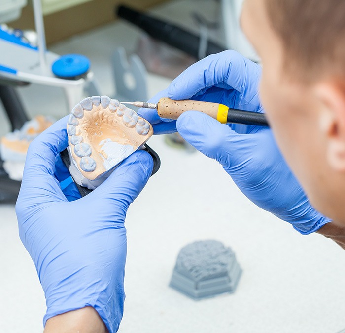 A lab technician making dentures